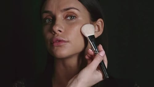 Woman Applying Makeup to Cheeks with Brush