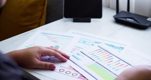 Close up of a dashboard chart and hands working on statistical and analytical data.