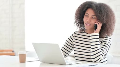 Young Woman Working On Laptop and Talking
