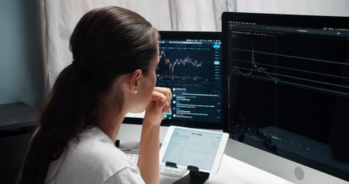 Woman Look at Screen and Analyzes the Stock Market Candlestick Charts From Home