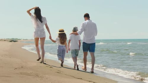 Family walking on beach along coast