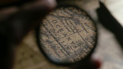 Magnifying Glass Exploring an Antique Paper Map