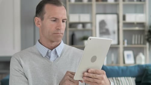 Man Uses Tablet in Home Setting