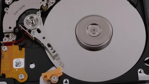 Opened Hard Disk Drive with Spinning Platter. Move of Writing Magnetic Head