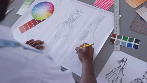 Mixed race man drawing in fashion office