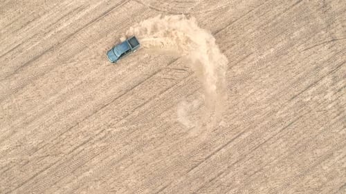 Aerial Shot of Powerful Pickup Drifting on Dry Ground. Black Off Road Vehicle Showing Performance