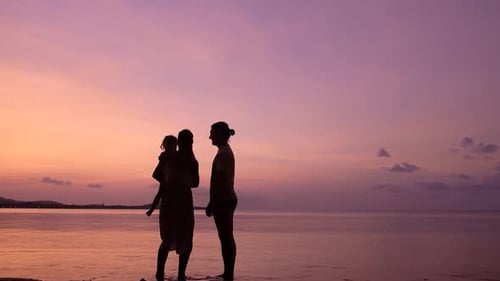 Friendly Family Hugs and Kisses on the Tropical Beach at the Sunset Time. Happy Family Concept.