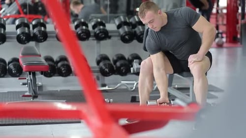 Man Lifting Dumbbells at the Gym