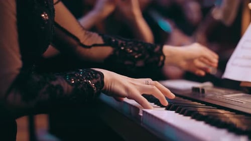 Woman Playing Piano in Dimly Lit Room