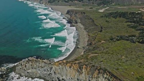 Rugged cliffs and colorful ocean in Pacific Coast of California