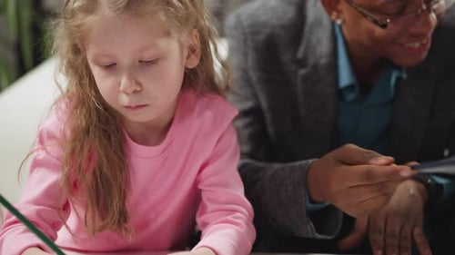 Child and Man Drawing Together at a Table