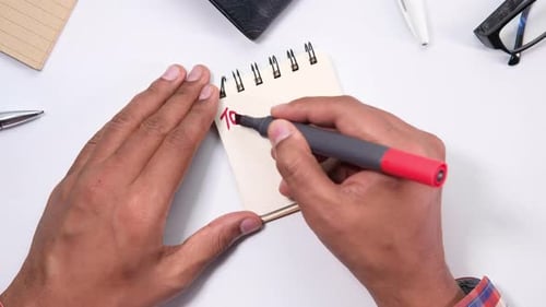 Top View of Man Hand Writing To Do List on a Notebook