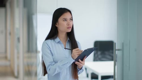 Woman Taking Notes in Modern Office