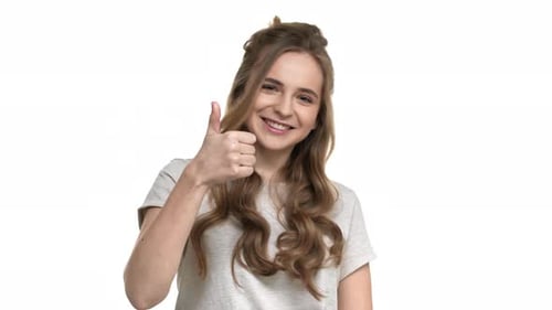 Woman Smiles and Gives Thumbs Up Gesture