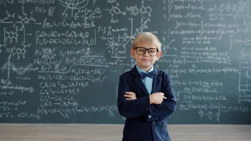 Boy in Suit Poses Before Chalkboard with Math
