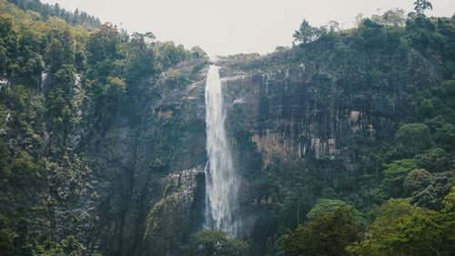 Beautiful Medium Shot, Landscape Background of Large Jungle Waterfall Rushing Down in Exotic
