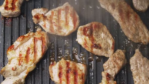 Process of cooking roast meat on a metal electric grill. Delicious prepared pork.