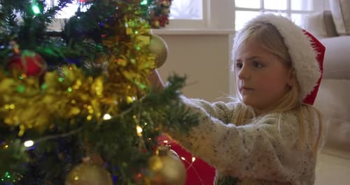 Child Decorates Christmas Tree in Home at Christmas