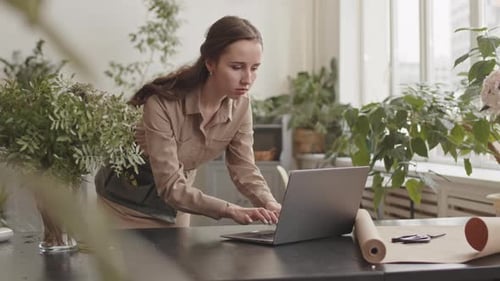 Woman Types at Laptop in Flower Shop