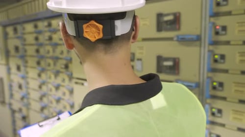 Engineer Inspecting Electrical Equipment With Clipboard