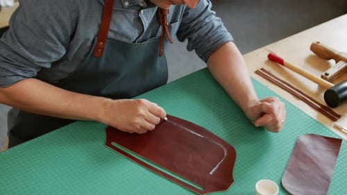 Craftsman Applying Glue on Leather Piece