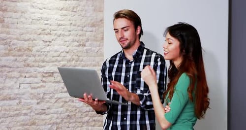 Woman and Man Collaborating on Laptop Indoors