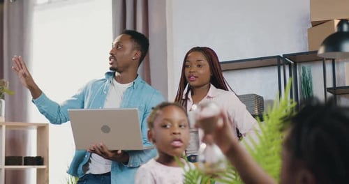 Pareja afroamericana con hijos de pie en su apartamento recién adquirido y planificando