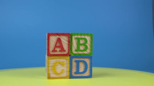 Colorful Alphabet Blocks Spelling ABCD on Yellow