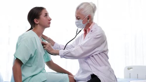 Doctor Listening to Young Adult Patient With Stethoscope