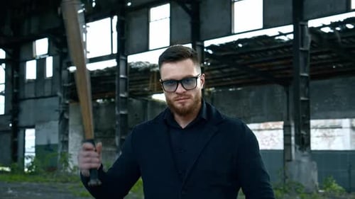 Aggressive man with baseball bat. Muscular man with baseball bat on the ruins