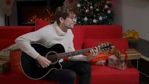 Young Man Playing Guitar for Christmas