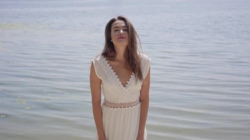 Woman Posing in Elegant White Dress by Lake