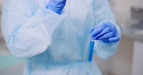 Laboratory Technician Adding Liquid to Test Tube