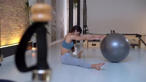 Fit Woman Doing Pilates with Ball in Studio