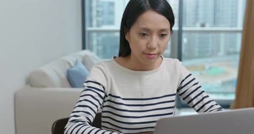 Woman Working on Laptop Computer at Home