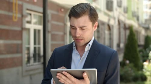 Nahaufnahme Geschäftsmann beim Surfen im Internet im Freien. Mann hält Touchpad auf der Straße