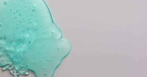 Pouring Turquoise Liquid on Gray Surface