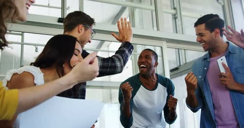 Excited Colleagues Celebrating Business Success in Workplace