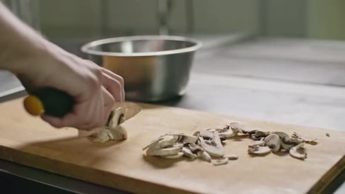 Slicing Button Mushrooms with Knife in Kitchen