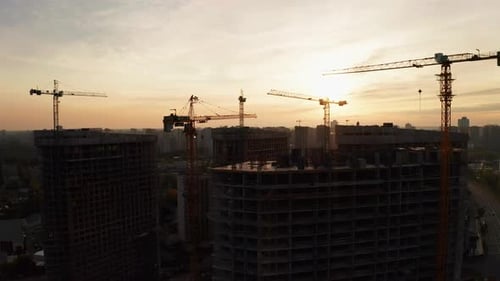 Construction Site with Cranes at Sunset