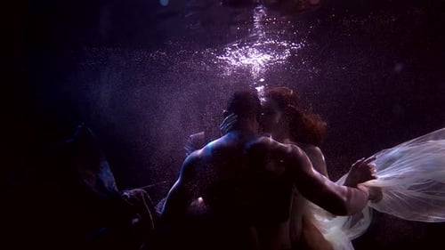 Woman and Man Are Holding Breath Underwater, Floating and Caressing Each Other