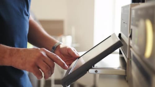 Man Operates a Machine with a Touchscreen