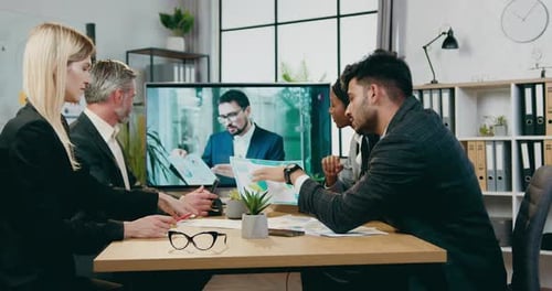 Team Collaborates During Video Conference in Modern Office