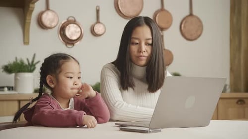 Young Adult and Child Using Laptop at Home