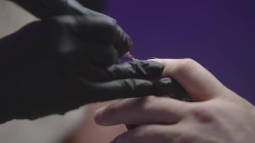 Manicurist Doing Man's Nails Using Small Drilling Device