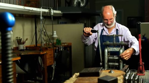 Goldsmith working on machine in workshop 4k