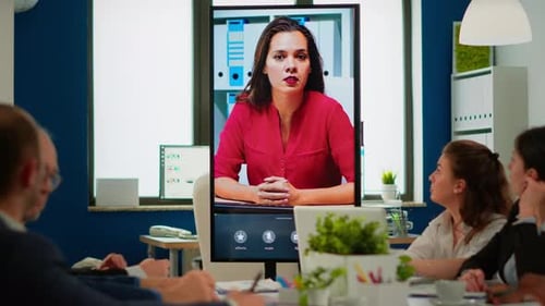 Vielfältiges Team von Mitarbeitern, die mit dem Projektmanager über die Webcam sprechen