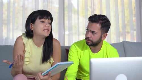 Young Adults Working Together on Laptop at Home