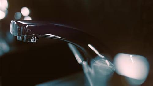 Chrome Faucet Close Up in Dark Bathroom