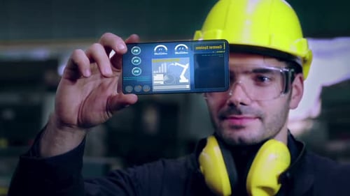 Un ouvrier d'usine utilise un futur dispositif d'écran holographique pour contrôler la fabrication